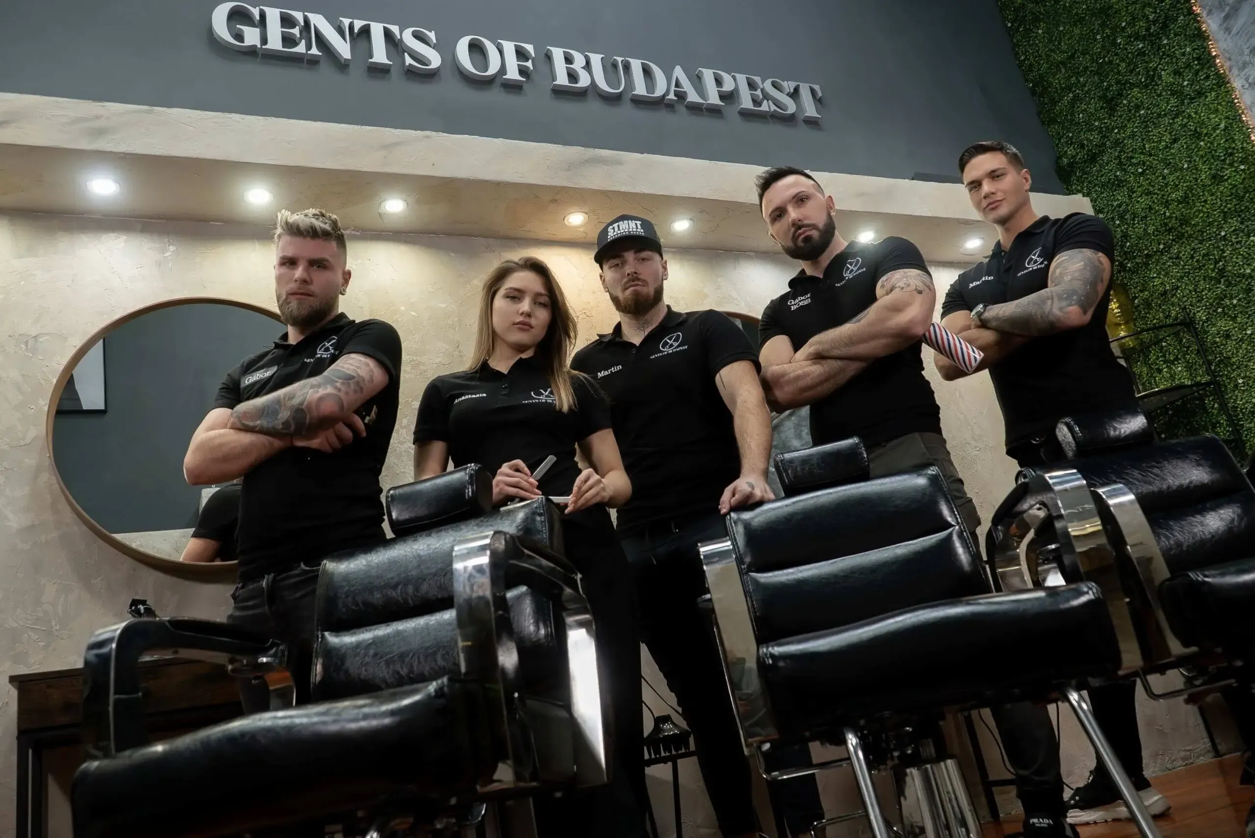 Csoportkép a borbélyszékek mögött, a Gents of Budapest felirat előtt.